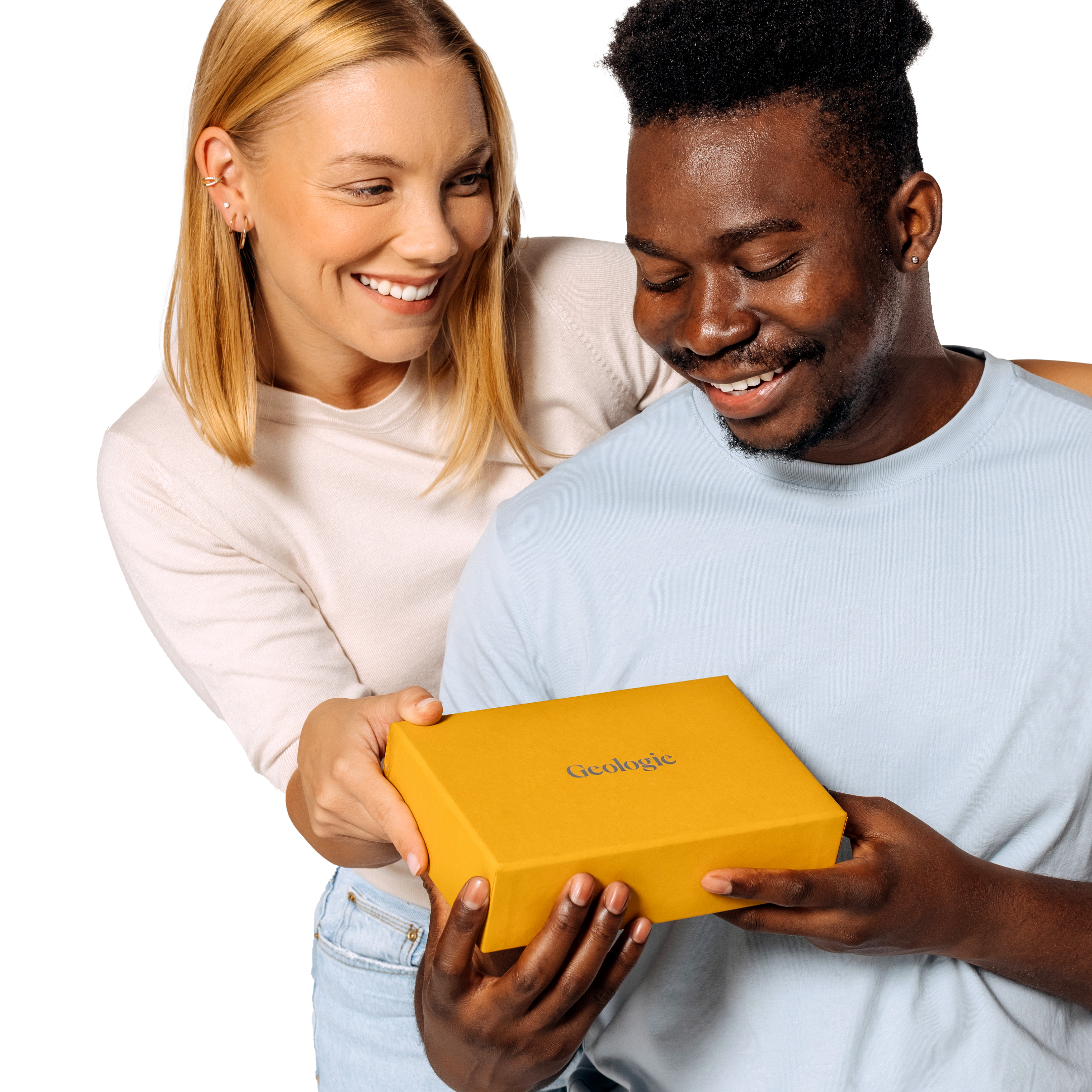 A woman and a man smiling while holding a yellow box of Geologie's Custom Control Hair Routine together against a black background, showcasing their hair innovations.